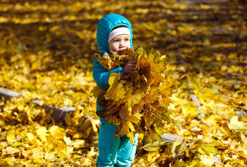 little girl throwing autumn leaves