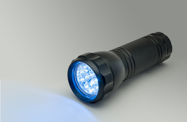 Black flashlight with blue LED light illumination