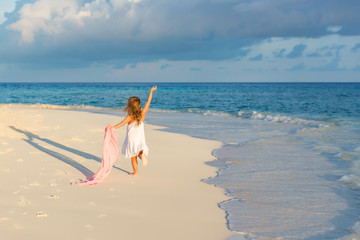 Fototapeta na wymiar Little girl playing on beautiful ocean beach