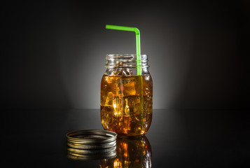 Ice tea in mason jar with green straw - Powered by Adobe