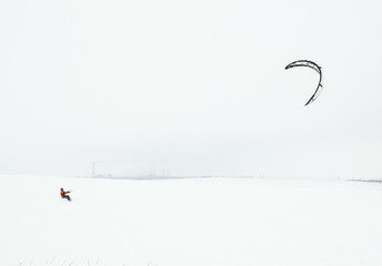 Snowboarder riding a kite on a background of an industrial enter