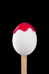 Egg on a wooden stick drenched colors