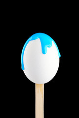 Egg on a wooden stick drenched colors