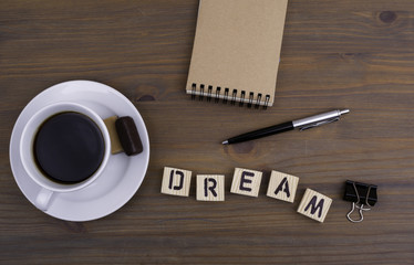 Coffee cup on a wooden table and text - Dream