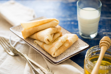 Crepes. Russian thin pancakes with honey. Breakfast table.