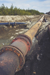 Steal big pipeline on a ground. Old pipes joint.
