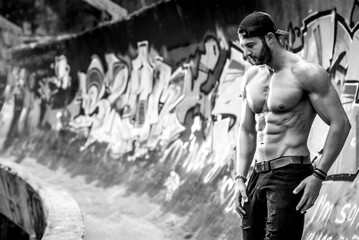 Handsome man posing in front of Graffiti wall
