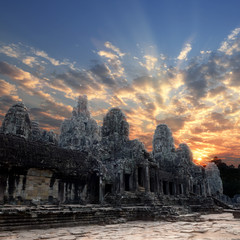 faces, heads of ancient Bayon Temple at Angkor Wat during sunrise, Siem Reap, Cambodia 