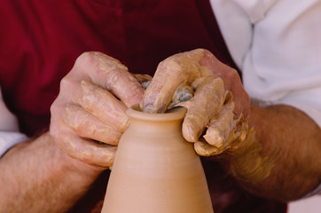 Detail on potter hands making a vase