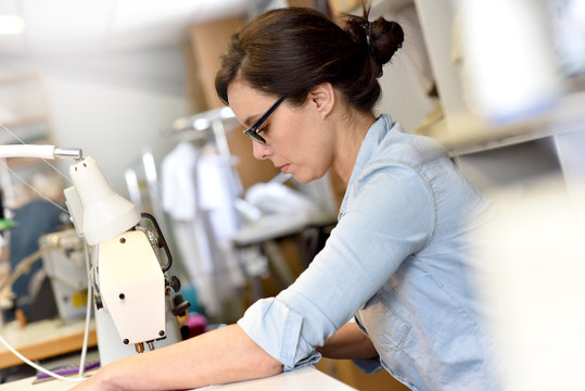 Portrait Of Seamstress Working On Sewing Machine