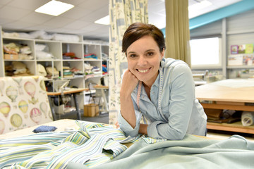 Portrait of happy seamstress woman in workshop