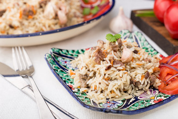 Traditional uzbek pilaf (plov) with tomatoes and red onion