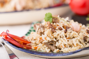 Traditional uzbek pilaf (plov) with tomatoes and red onion