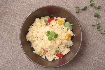 Couscous and roasted vegetables salad in a brown dish
