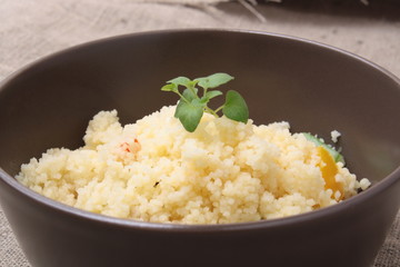 Couscous and roasted vegetables salad in a brown dish