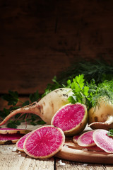 Cut pink radish, vintage wooden background, selective focus