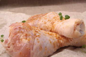 raw chicken legs with spices on background on paper