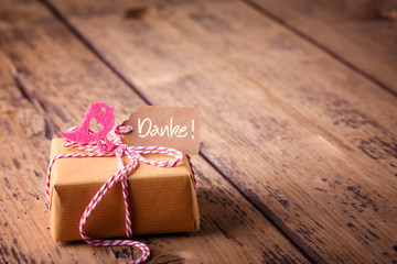 Muttertag - Geschenk in Packpapier und Karte mit Aufschrift  DANKE auf Holz