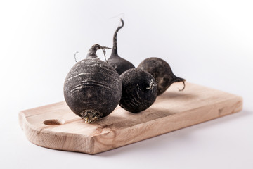 black beet group on wooden cutting board and white background