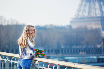 Girl with bunch of red tulips near the Eiffel tower