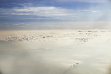 Clouds and sky as seen through window of an aircraft