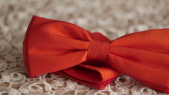 Panning shot of red bow tie on table