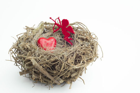 Heart and cupid figure placed into a wooden bird nest