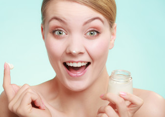 Obraz na płótnie Canvas woman applying cream on her skin face.