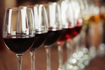 Many glasses of different wine in a row on bar counter