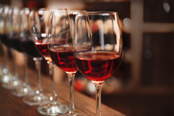 Many glasses of different wine in a row on bar counter