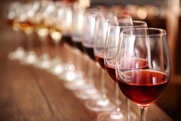 Many glasses of different wine in a row on bar counter