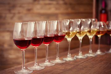 Many glasses of different wine in a row on bar counter