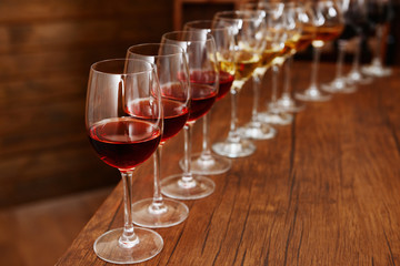 Many glasses of different wine in a row on bar counter