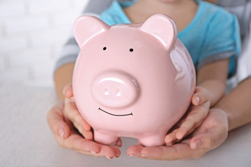 Obraz na płótnie Canvas Savings concept. Hands holding piggy bank, close up
