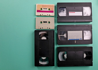 Set of old audio and video cassettes on turquoise background
