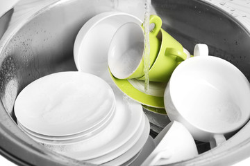 Fototapeta na wymiar Pile of dishes in sink closeup
