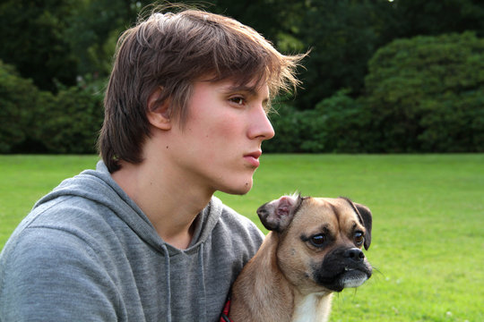 Portrait Jugendlicher mit Hund beobachtet etwas im Park