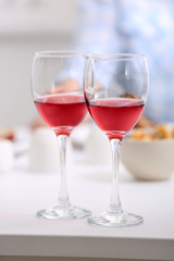 Dinner with glasses of wine on light blurred background