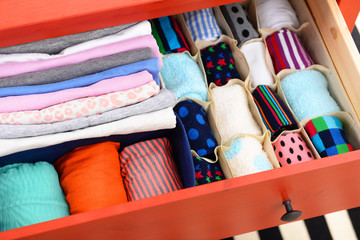 Fototapeta na wymiar Folded clothes in chest of drawers closeup