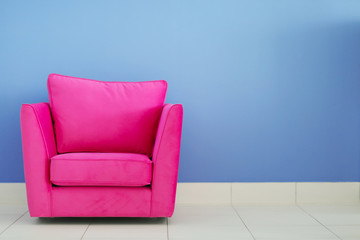 Comfortable armchair against blue wall background