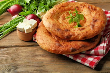 Fresh fried bread with other products on wooden table closeup