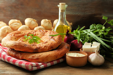 Fresh fried bread with other products on wooden table closeup