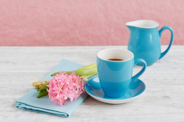 Cup of black coffee and pink flower