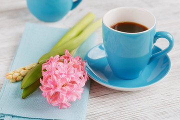 Cup of black coffee and pink flower
