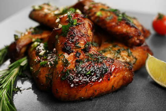 Baked chicken wings with spices on grey background
