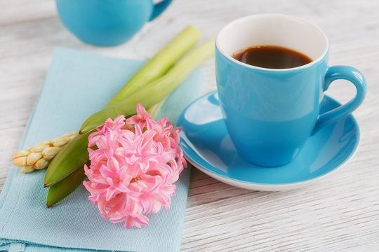 Cup of black coffee and pink flower