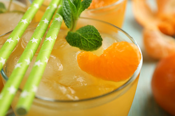 Fresh cocktails with ice, mint and tangerines on the wooden table, close up