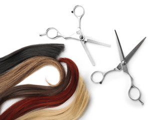 Hairdresser's scissors with varicolored strands of hair, isolated on white