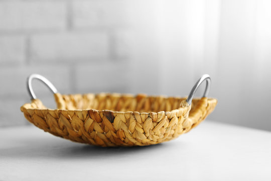 Wicker salver with metal handles on wooden table background, closeup