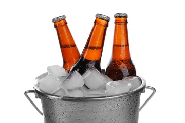 Beer bottles in ice bucket, isolated on white